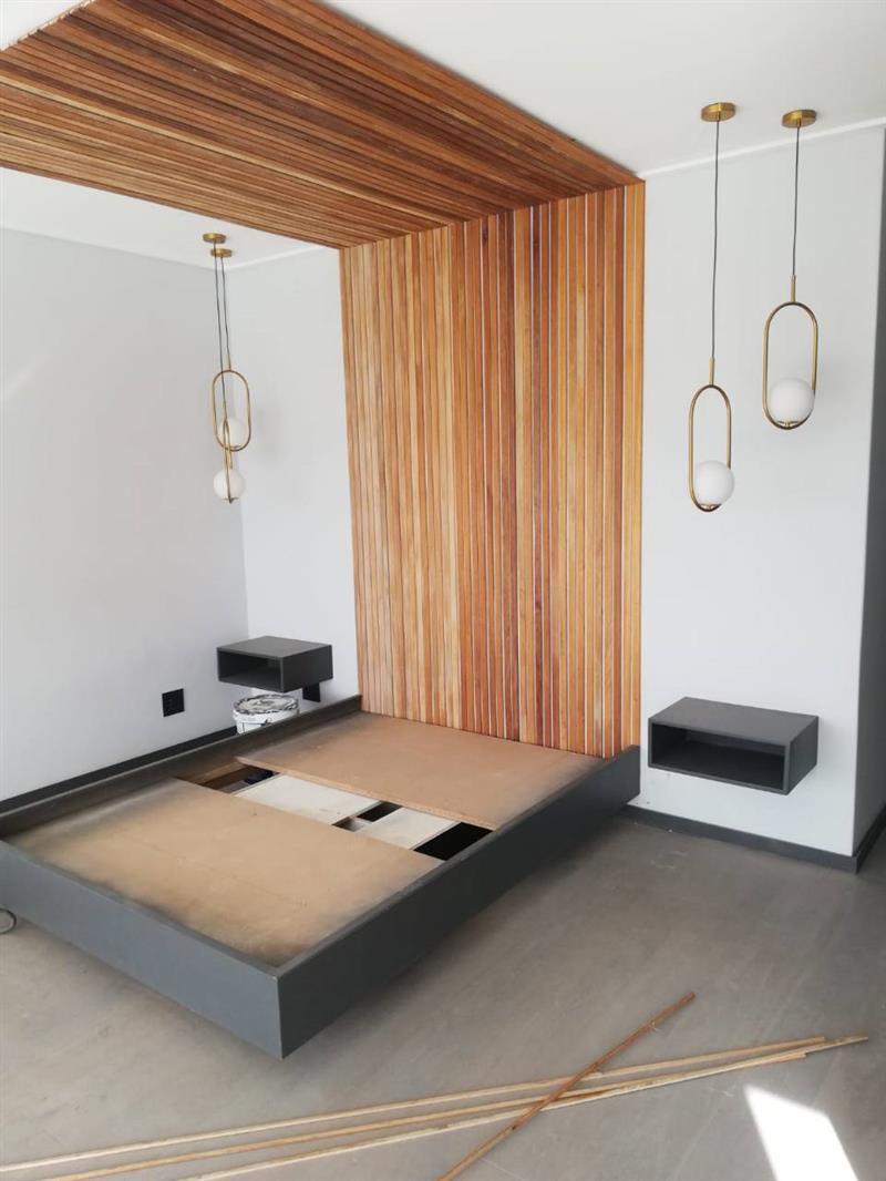 Finished bedroom pendant lighting around a timber feature wall