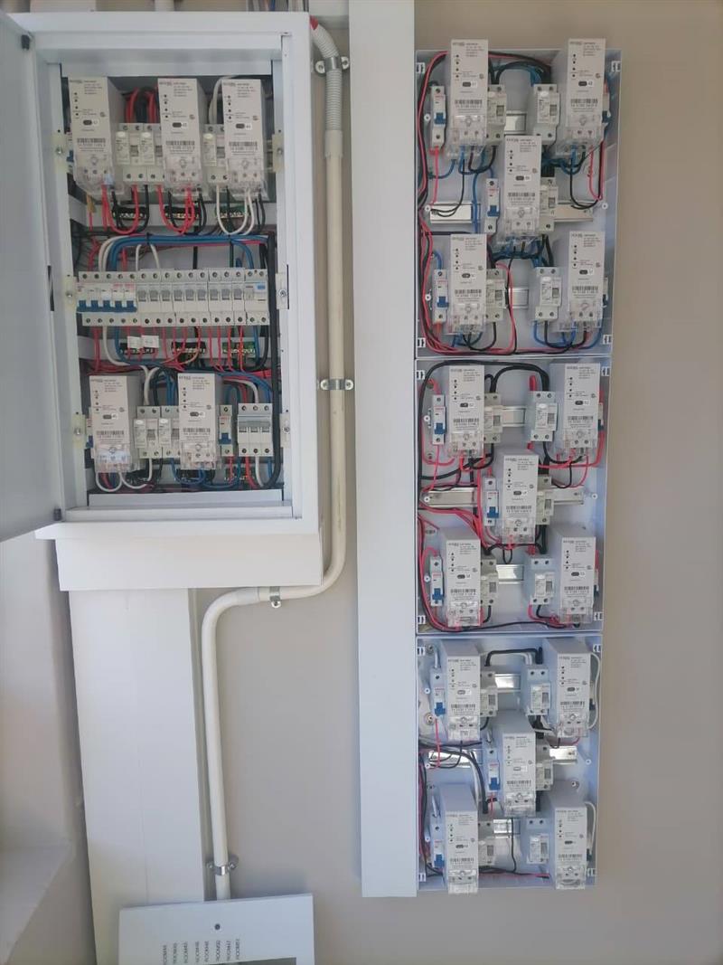 Completed distribution board wiring with labelled electrical meters