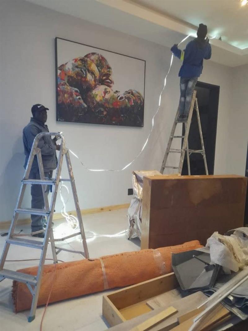 Team installing LED strip lighting inside a room
