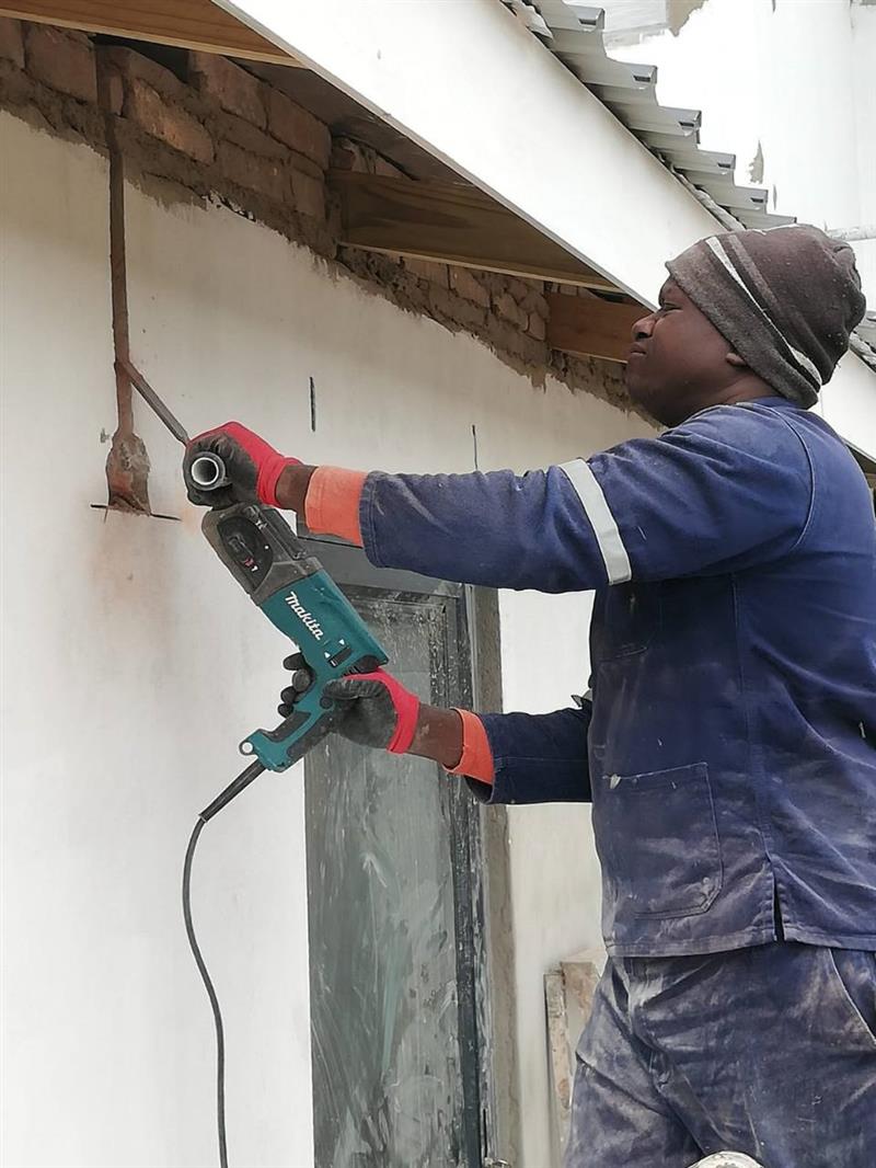 Electrician chasing a wall for electrical conduit installation